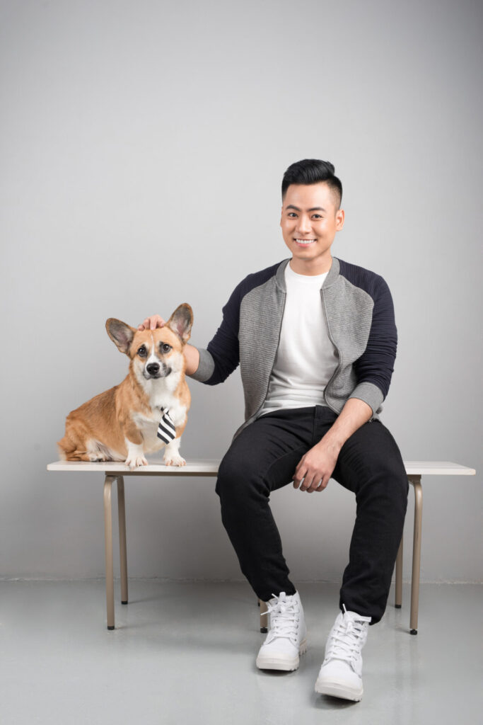 Handsome young asian man sitting with his dog on chair