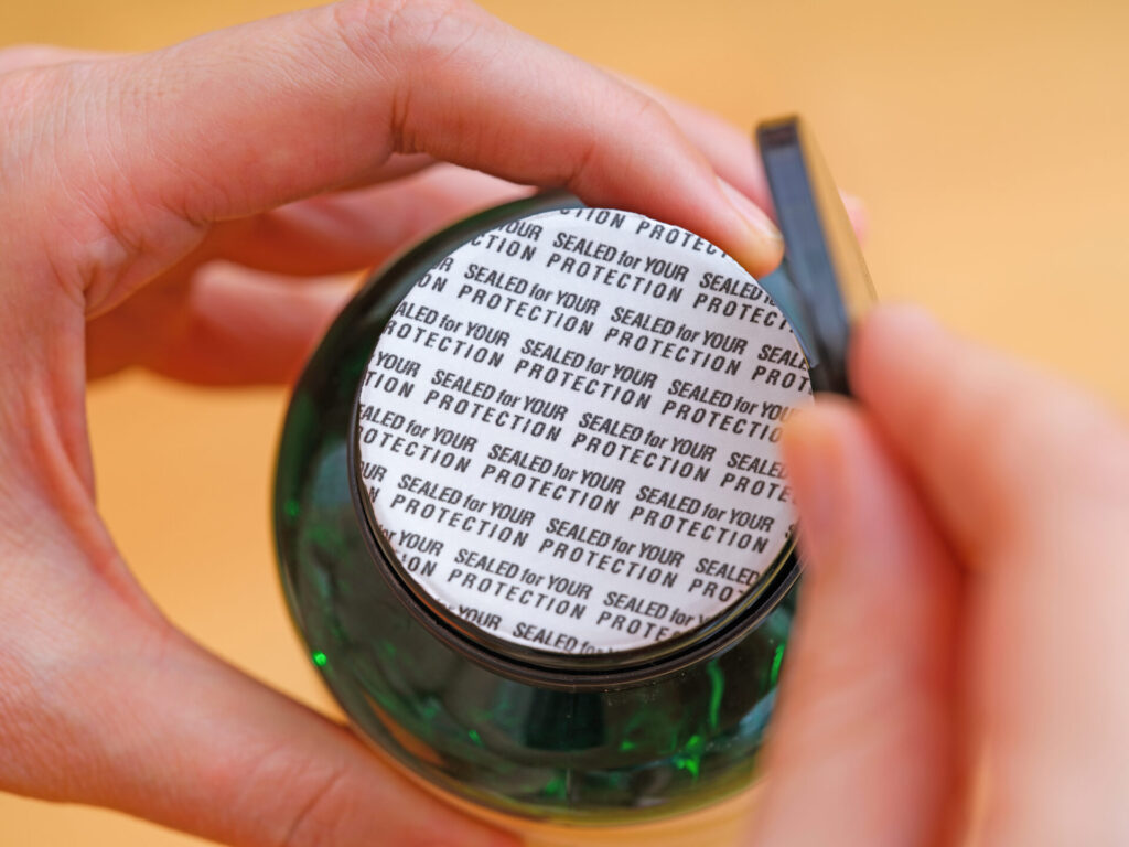 A Woman Opening a Sealed Bottle of Pills with the World Sealed F